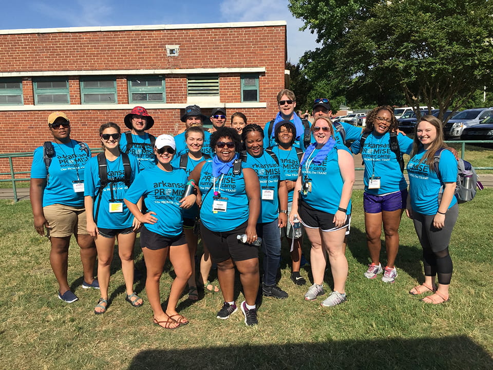 16 Staff members standing outside wearing blue PROMISE shirts